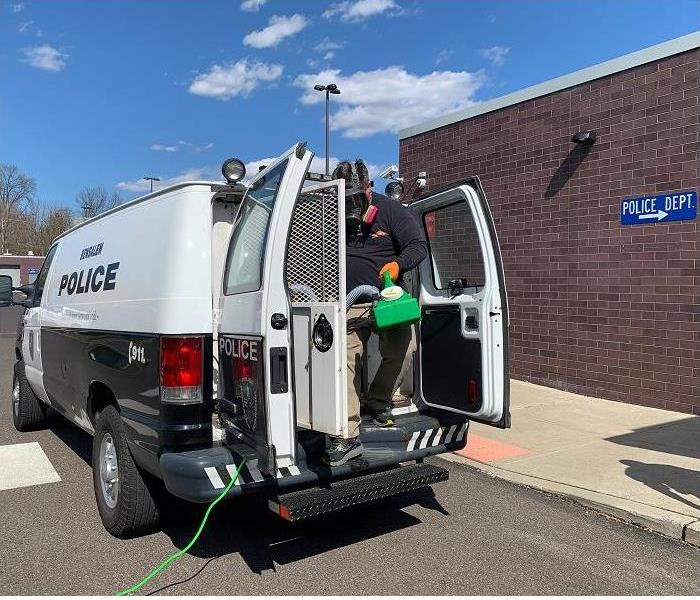 SERVPRO technician cleaning police van. 