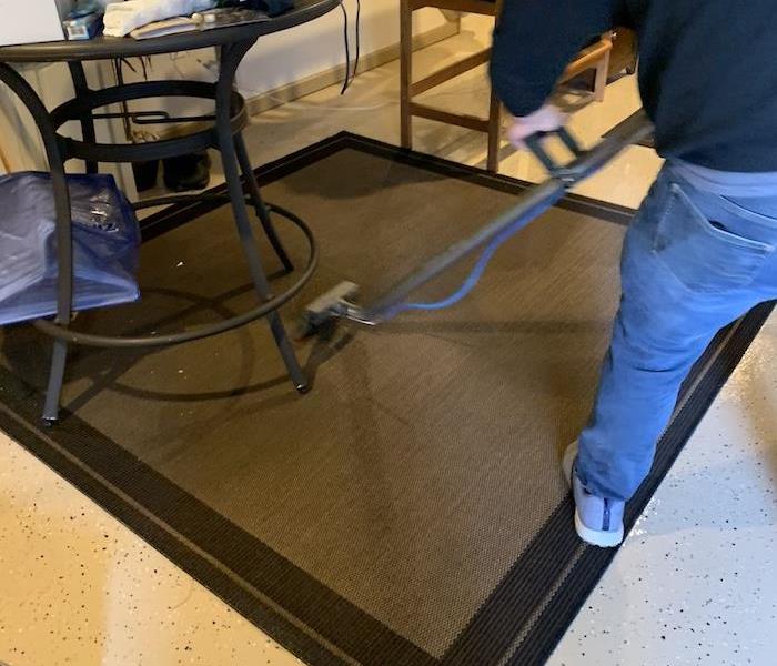 SERVPRO tech extracting water from an area rug