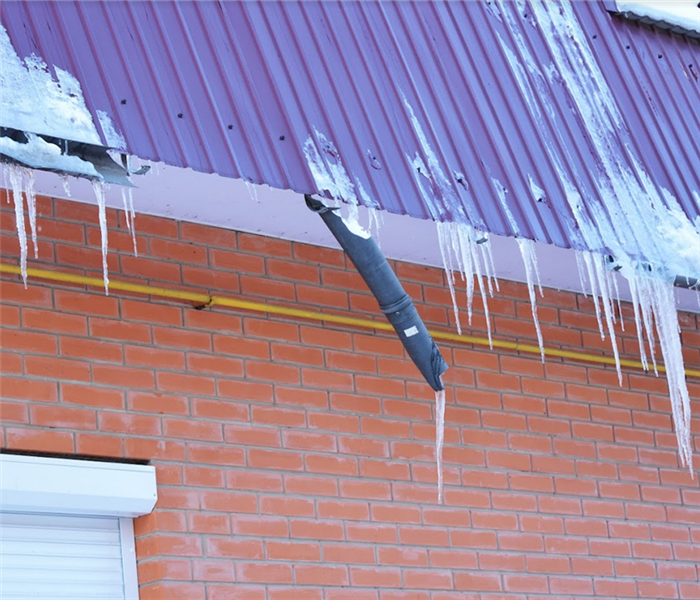 icicles hanging off of the roof and off of broken pipes